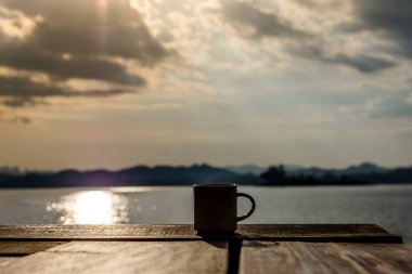 Siluet kahve fincanı tahtada sabah bulanık arkaplanlı..