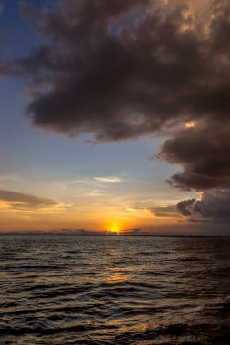 Bulutlu ve siluetli gün batımı gökyüzü altın çağda gölde..