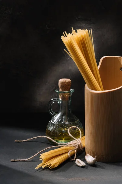 Racimos Espaguetis Crudos Con Ajo Botella Aceite Oliva Sobre Negro — Foto de Stock