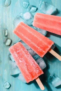Sweet red fruit Popsicles on wooden background clipart