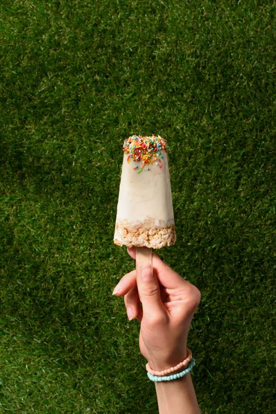 Weibliche Hand Mit Süßem Eis Stiel Auf Grünem Grashintergrund — Stockfoto
