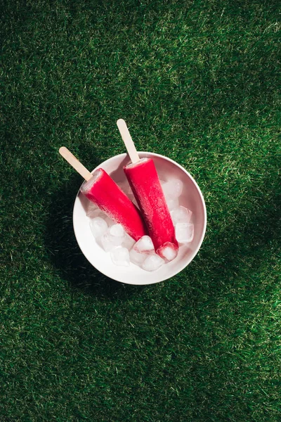 Cuenco Con Paletas Rojas Cubitos Hielo Sobre Fondo Hierba Verde — Foto de Stock