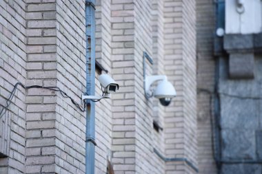 close up view of security cameras on brick building facade clipart