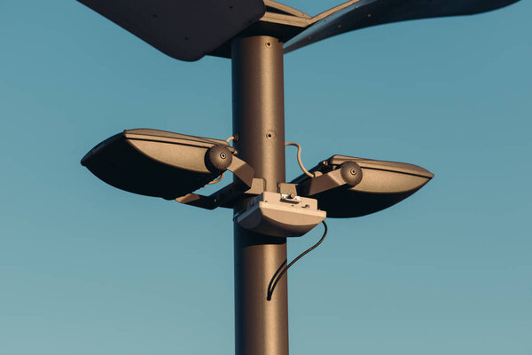 close up view of street lights on pole with blue sky on background