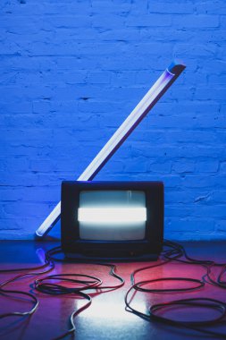 Düzenlenmiş retro televizyon seti, kabloları ve tuğla duvar arka plan ile lamba tonda resmi