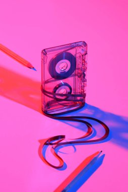 close up view of retro audio cassette and pencils on pink backdrop clipart
