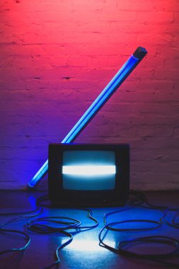 Düzenlenmiş retro televizyon seti, kabloları ve tuğla duvar arka plan ile lamba tonda resmi