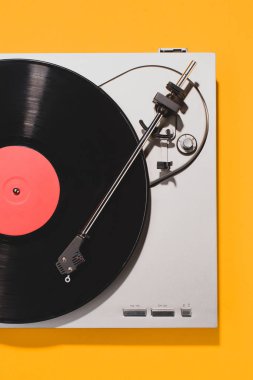 top view of retro vinyl player and record isolated on yellow clipart