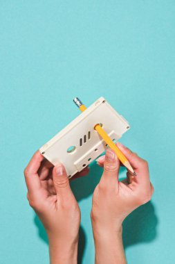 kısmi görünümünü beyaz retro ses kaseti ve mavi izole kalem tutan kadın