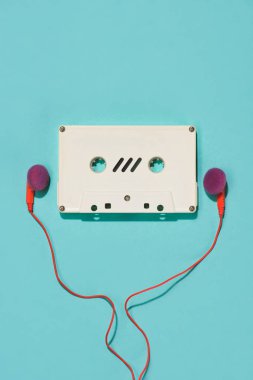 düz lay beyaz retro ses kaseti ve mavi izole kulaklık ile