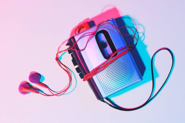 toned picture of retro cassette player and earphones on tabletop clipart