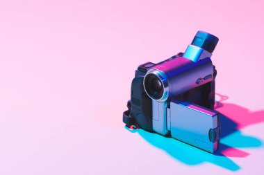 close up view of digital video camera on pink background clipart