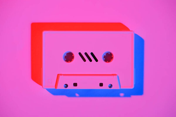 toned pink picture of retro audio cassette on pink surface