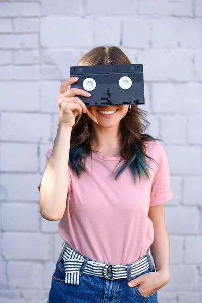 Затемнений Вид Усміхненої Жінки Прикриває Очі Ретро Відеокасетою Руці Проти — стокове фото