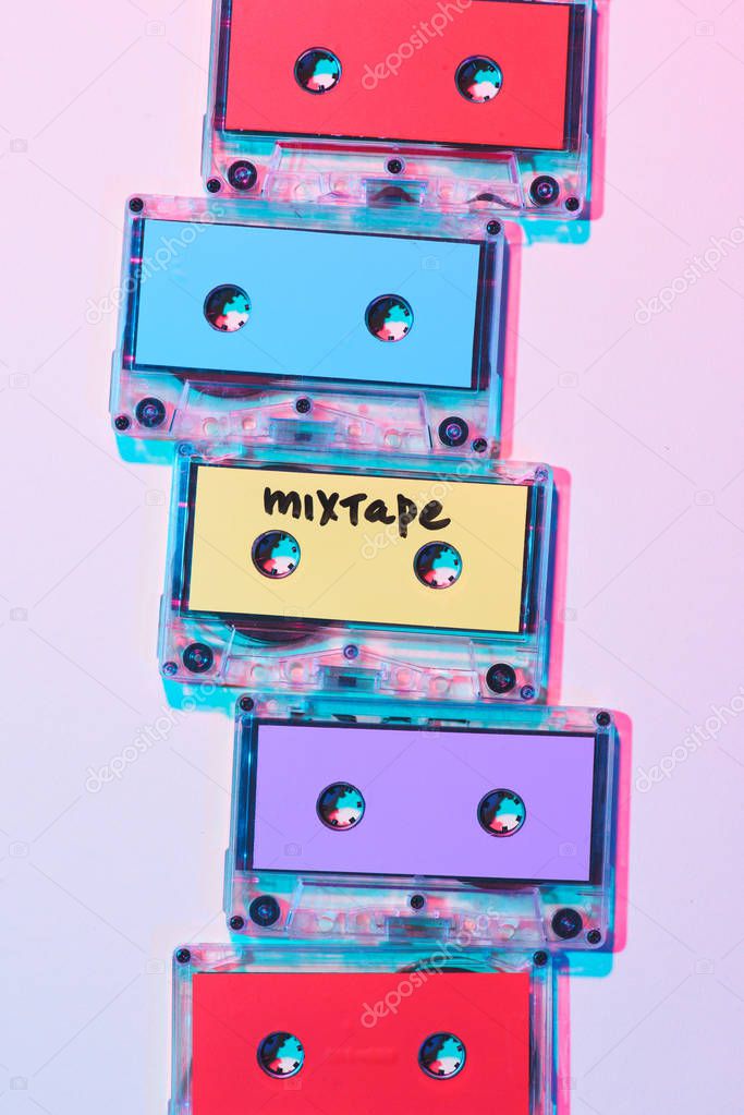 top view of arranged colorful audio cassettes with mixtape lettering on purple background