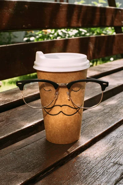 Close View Disposable Cup Mustache Sign Eyeglasses Wooden Bench — Stock Photo, Image