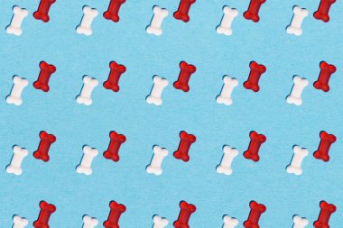 top view of gummy candies in shape of bones pattern on blue clipart