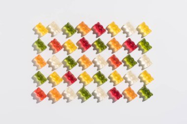 top view of colorful gummy bears pattern on white clipart