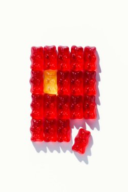 top view of red defragmented rectangle of gummy bears on white clipart