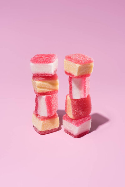 stacked gummy candies on pink surface
