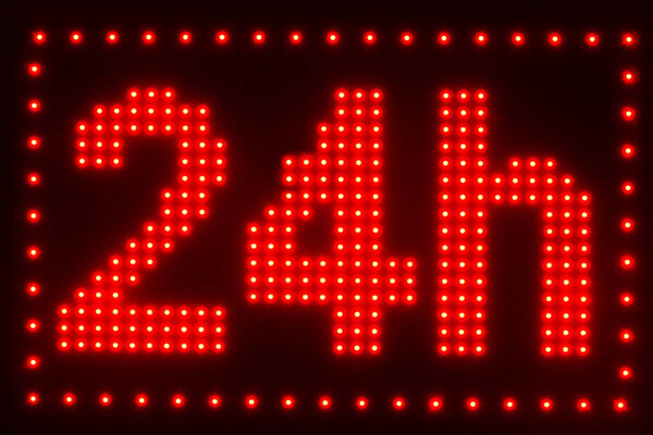 close up view of illuminated twenty four hour sign on dark background