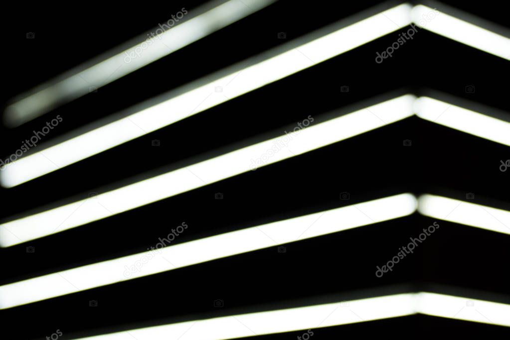 close up view of blurred white lightning lamps on black background