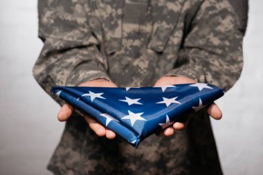 asker askeri üniforma gösteren katlanmış bayrağı elinde, Amerika bağımsızlık günü kavramı kısmi görünümü