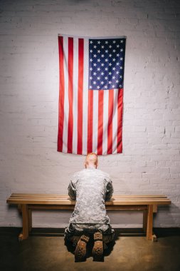 Dikiz asker askeri üniforma beyaz tuğla duvar, Amerika bağımsızlık günü kavramı Amerikan bayrağı ile dua içinde