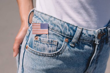 partial view of woman in jeans with american flagpole in pocket, americas independence day holiday concept clipart
