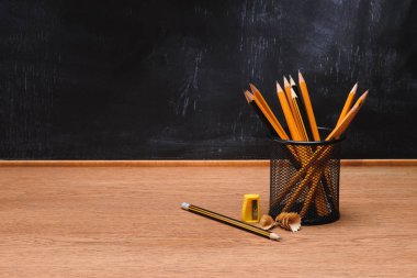 kalemler ve kalemtıraş üzerinde ahşap masa boş tebeşir tahtası okulun önünde ile Resepsiyon Organizatör görünümünü yakın