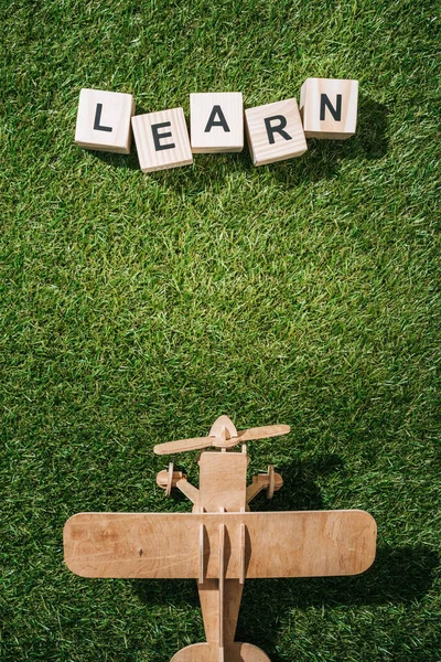 木制玩具平面的顶部观与绿草块的学习题词 — 图库照片
