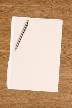 elevated view of folder with papers and pen on wooden table  clipart