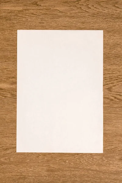 Boş Beyaz Kağıt Ahşap Masa Üzerinde Yukarıdan Görüntülemek — Stok fotoğraf