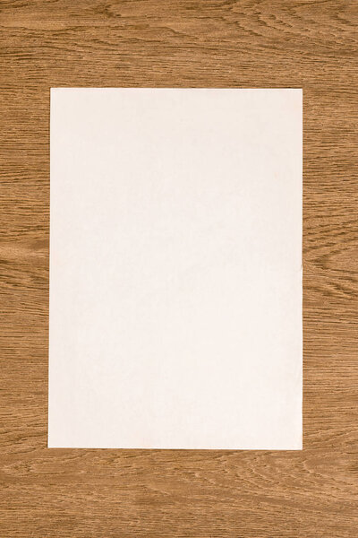view from above of blank white paper on wooden table