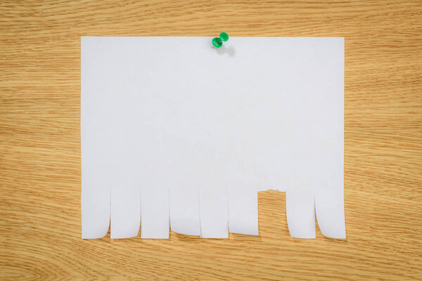 top view of empty paper for ads with drawing pin on wooden board 