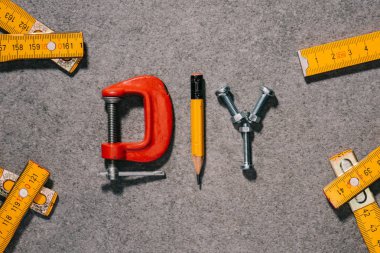 top view of word diy made of tools on grey surface clipart