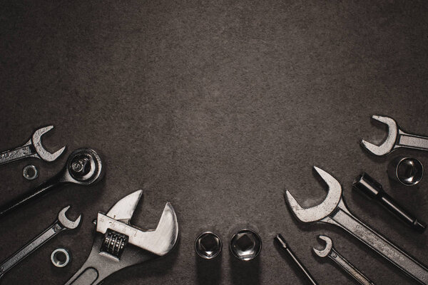 flat lay with different wrenches, monkey wrench and nuts on grey surface