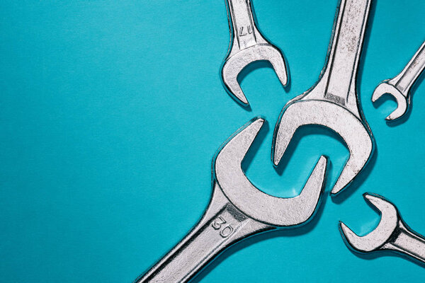 elevated view of different sized wrenches isolated on blue