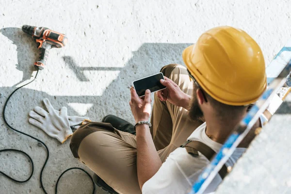 Overhead View Builder Protective Helmet Using Smartphone Blank Screen Construction — Stock Photo, Image