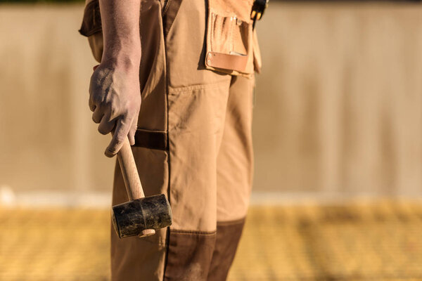 обрезанный образ строителя в мундире с молотком
 