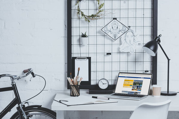 laptop with loaded booking page on table in modern office