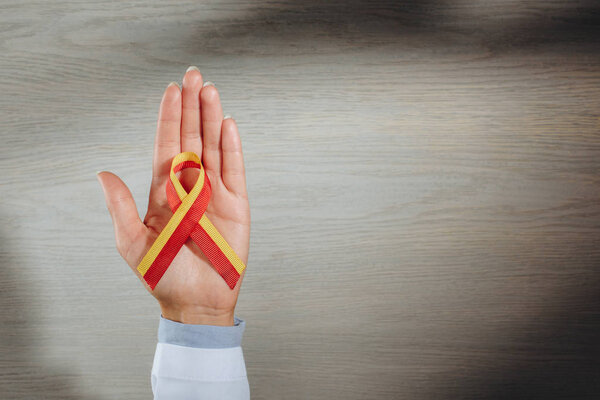 partial view of female doctor holding ribbon, world hepatitis day concept