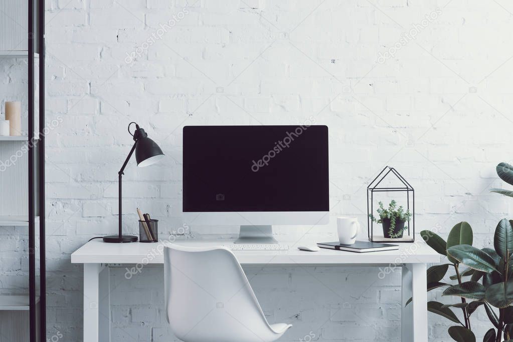 computer, table, chair and plants in modern office 