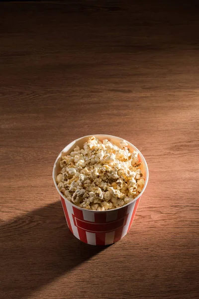 Nahaufnahme Eines Einwegeimers Mit Popcorn Auf Einer Hölzernen Tischplatte — Stockfoto