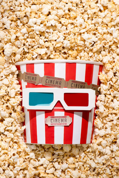 flat lay with arrangement of disposable bucket with popcorn, retro cinema tickets and 3d glasses