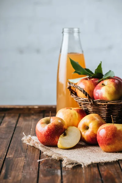 Nahaufnahme Von Glasflasche Mit Apfelsaft Und Äpfeln Korb Auf Holztischplatte — Stockfoto