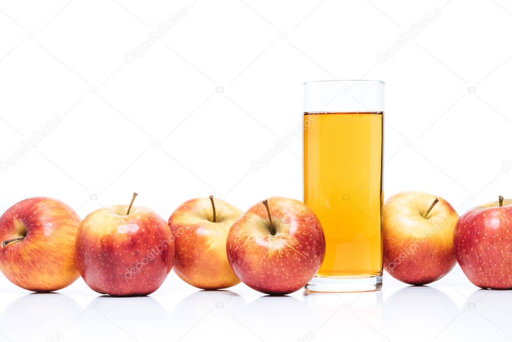 close up view of glass of apple juice and fresh apples isolated on white