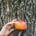 Částečný pohled dívka drží s apple na hlavu