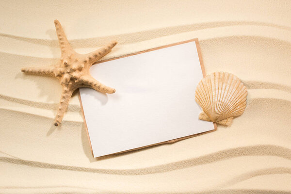 Плоский лежал с морской звездой, морем и бланшированной бумагой на песке
