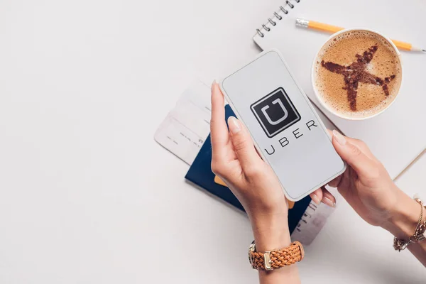 Обрезанный Снимок Женщины Смартфоном Логотипом Uber Экране Столе Чашкой Кофе — стоковое фото